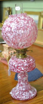 Lot 476 - A late 19th/early 20th century mottle pink glass oil lamp with matching shade, 51cm high