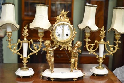 Lot 480 - A gilt metal and white marble striking mantel clock with garniture, retailed by Chaussey, Le Havre