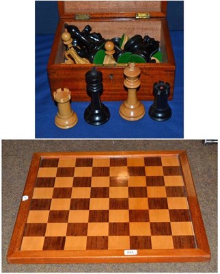 Lot 645 - A mahogany hinged box containing stained and natural chess pieces and a chess board 60cm by 60cm