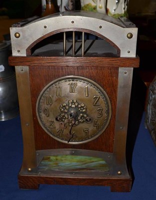 Lot 685 - A Jugendstil oak and metal mounted mantel clock, arched top, over an embossed brass 14.5cm...