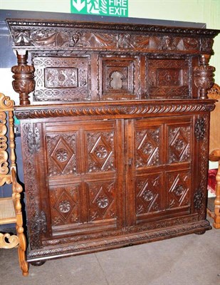 Lot 741 - An impressive carved oak court cupboard, the frieze richly carved with dragons and figural...