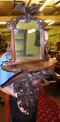 Lot 879 - A 19th century carved mahogany mirror back wall bracket decorated with an eagle