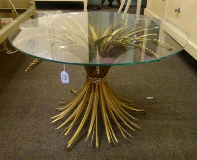 Lot 881 - Coffee table with circular glass top, with wrought metal base coloured gold and in the form of...