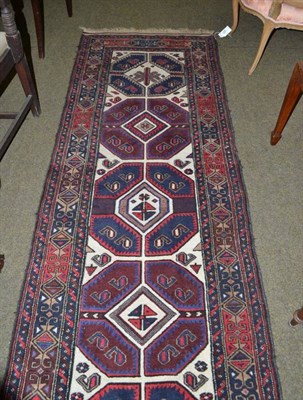 Lot 928 - A narrow piled Sumakh Belouch runner, the ivory field with a column of octagons enclosed by...