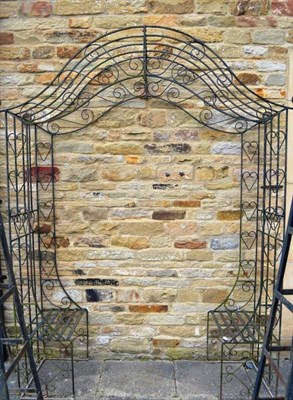 Lot 1424 - A wrought iron garden seat with arched canopy, 257cm high