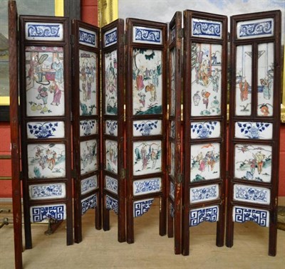 Lot 1467 - A 19th century Chinese eight leaf folding screen, polychrome decorated with figures amongst a...