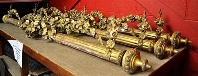 Lot 1486 - Four 19th century gilt gesso fluted poles with flower garlands and ribbon tied motifs, 230cm long