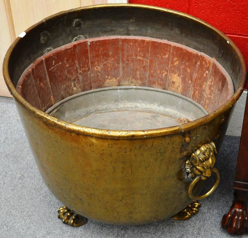 Lot 1497 - Large brass log bin with lion mask loop handled and claw feet, 70cm diameter