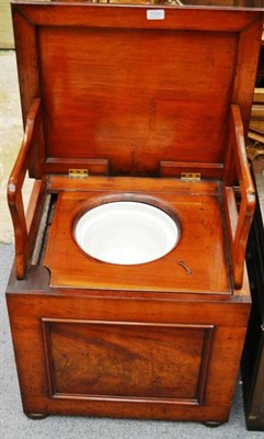 Lot 1534 - A late Victorian mahogany box commode, the hinged lid with folding arm rests and ceramic bowl