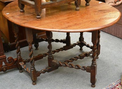 Lot 1577 - An 18th century fruitwood drop leaf table raised on turned spiral oak legs, 122cm wide