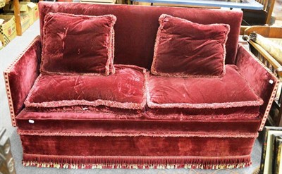 Lot 1598 - A 20th century knoll sofa upholstered in red velvet with horsehair filled cushions, 170cm wide