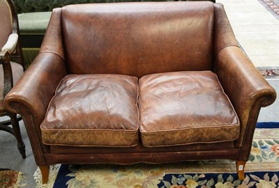 Lot 1602 - A modern tan leather upholstered two seater settee