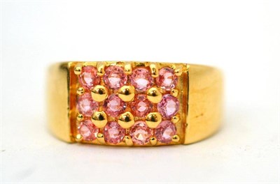 Lot 4 - An 18ct gold padparadscha grid ring, twelve round mixed cut pinky-orange sapphires in yellow...