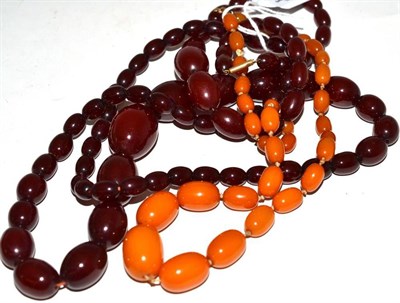 Lot 16 - Three amber necklaces, two cherry red colour, one orangey-yellow colour, all of graduated...
