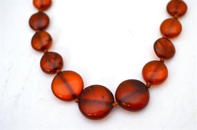 Lot 33 - A graduated amber flat disc bead necklace, of orangey-colour, length 45.5cm