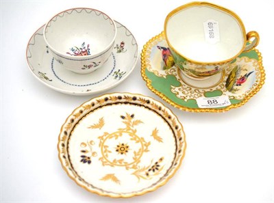 Lot 88 - A Flight Barr & Barr tea cup and saucer, decorated with exotic bird panels on an apple green...