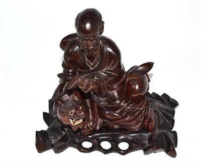 Lot 100 - Chinese carved wood figure group of a sage and tiger, 15.5cm high, on stand