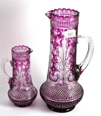 Lot 107 - Two cut glass amethyst flash jugs, 34cm and 22cm