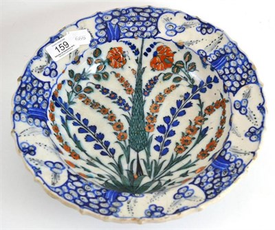 Lot 159 - A 19th century Iznik bowl, decorated with a cypress tree, tulips and sprays, 28cm diameter