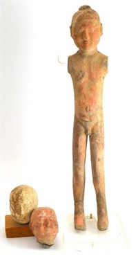 Lot 185 - Chinese terracotta tomb figure, possibly Han dynasty, 57cm high, and two similar heads (3)