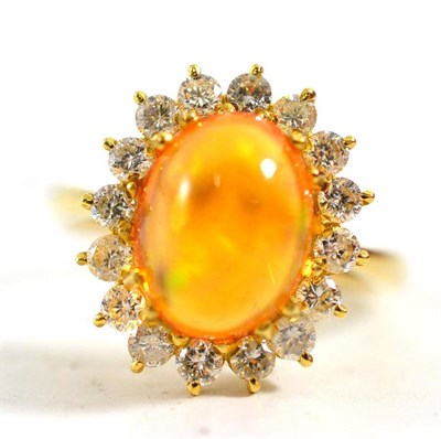 Lot 116 - An 18ct gold fire opal and diamond cluster ring, a cabochon fire opal within a border of...