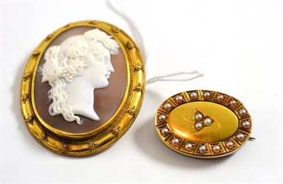 Lot 126 - A cameo brooch, depicting a Bacchante, in a yellow rubbed over setting within a rope twist...