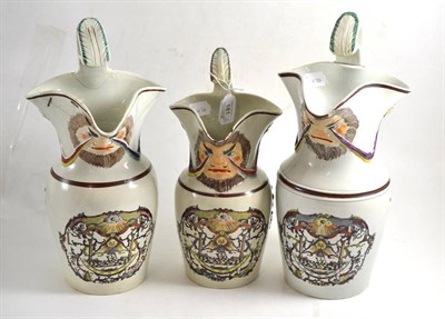 Lot 181 - A graduated set of three 19th century pearlware mask jugs decorated with Masonic symbols,...