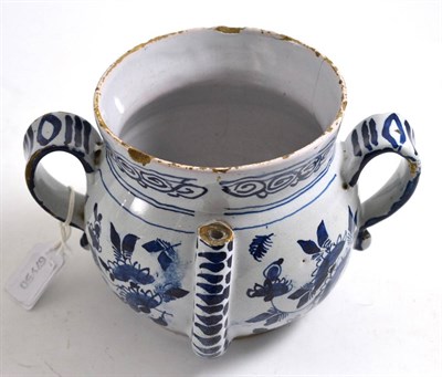 Lot 211 - An English Delft posset pot, circa 1720, of baluster form with twin scroll handles, painted in blue