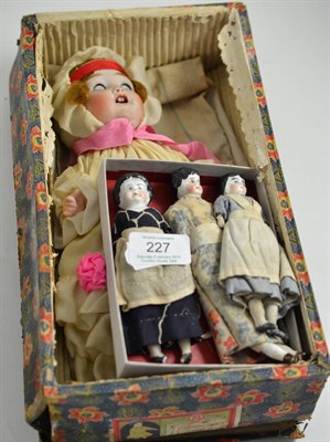 Lot 227 - A bisque head doll in original box and three porcelain doll's house dolls