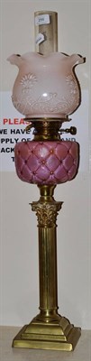 Lot 256 - A Victorian brass oil lamp with pink reservoir, 70cm high