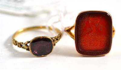 Lot 296 - A cornelian intaglio ring, on a forked shoulder shank, finger size O and a foil backed garnet...