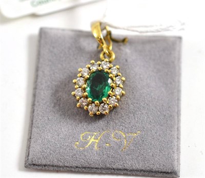 Lot 302 - An 18ct gold emerald and diamond pendant, the oval mixed cut emerald within a border of round...