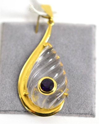 Lot 308 - An 18ct gold rock crystal and amethyst pendant, a teardrop carved rock crystal within a yellow...