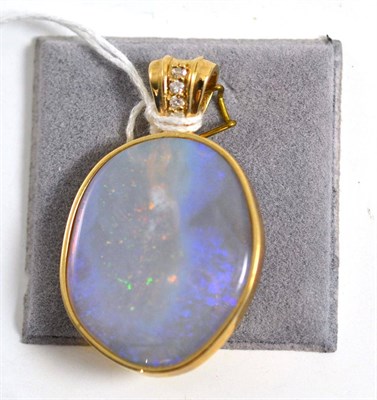 Lot 345 - A 9ct gold opal and diamond pendant, the unevenly shaped polished opal within a yellow collet...