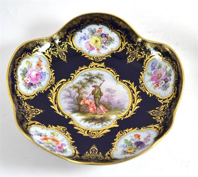 Lot 398 - Late 19th century Meissen blue ground dish painted with rustic lovers, 19cm diameter