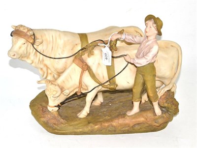 Lot 409 - Royal Dux figure group modelled as young boy with two bulls, 33cm wide (base)