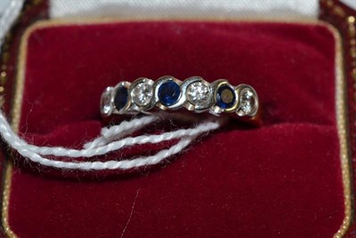 Lot 462 - An 18ct gold sapphire and diamond half eternity ring, round brilliant cut diamonds alternate...