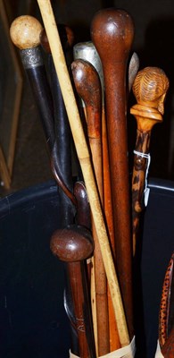 Lot 484 - Bundle of walking sticks including ebonised examples and carved walking stick, the handle formed as