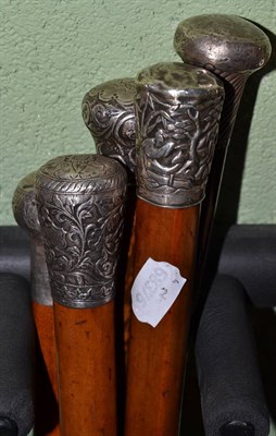 Lot 487 - Three Malacca walking sticks with silver pommels and two other silver topped examples