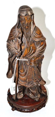 Lot 535 - A Chinese bronzed spelter figure of a sage, standing holding a staff and a fan, on a carved...