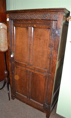 Lot 656 - A joined oak cupboard, 17th century and adapted, the frieze with carved S scrolls above a...