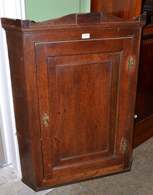 Lot 668 - George III oak hanging corner cupboard