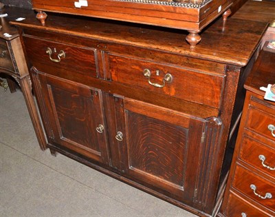 Lot 679 - An 18th century oak sideboard, fitted two drawers above cupboard doors with flutes stiles