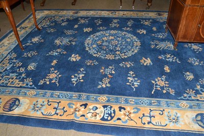 Lot 711 - Chinese carpet, the mid indigo field with central roundel surrounded by plants, framed by spandrels