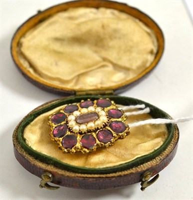 Lot 221 - A garnet and seed pearl mourning brooch, a locket panel within a border of split pearls to an outer