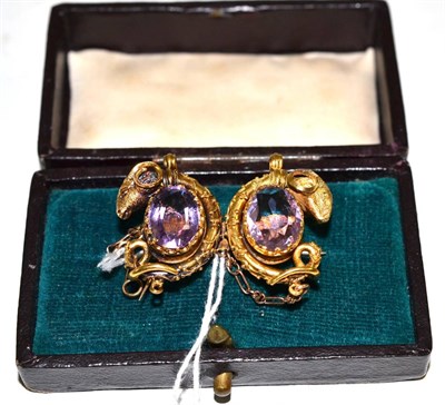 Lot 237 - A Victorian amethyst brooch with ram's head motifs, two oval cut amethysts in yellow claw...