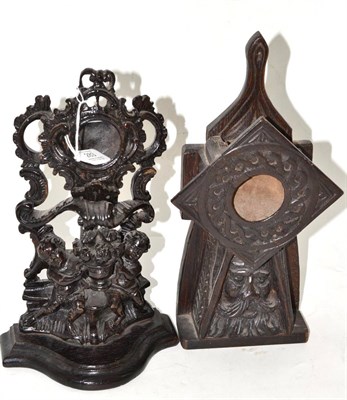 Lot 283 - A small treen watch stand, depicting two cherubs holding an urn of flowers, 30cm high, a carved oak