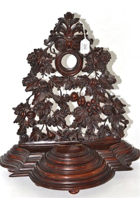 Lot 299 - A large treen watch stand, highly decorated with leaves and fruit, stepped base with a single...