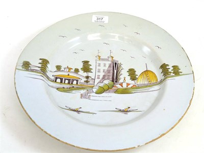 Lot 317 - An English Delft charger, circa 1750, painted in colours with a country house and gardens,...