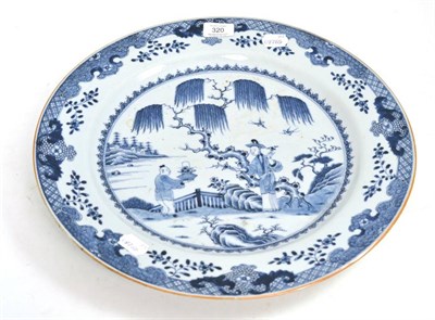 Lot 320 - A Chinese porcelain charger, Qianlong, painted underglaze blue with figures in a fenced garden,...